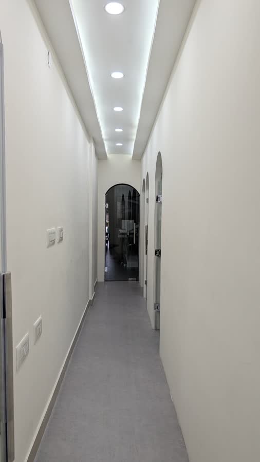 The corridor to the treatment rooms, with arched glass doors along one side